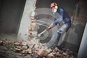 Demolition work and rearrangement. worker with sledgehammer destroying wall