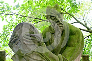 Demon statue covered in moss