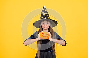 Demoness. jack o lantern. happy halloween. child in witch hat. kid hold spooky pumpkin. witchcraft and enchantment