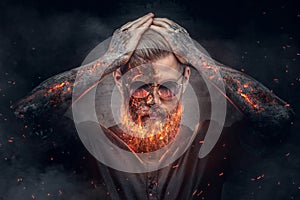 Demonic male with burning beard and arms.