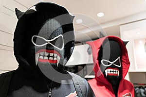 A demons mask, a couple anorak in black and red costume on devil mask