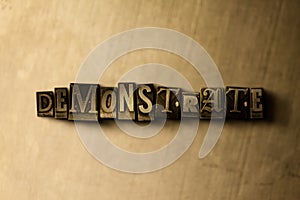 DEMONSTRATE - close-up of grungy vintage typeset word on metal backdrop