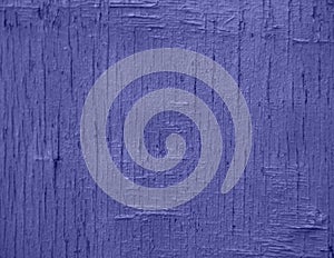 Demonstrating the fashionable color of 2022 - purple. A background of purple, peeling paint on an old wooden wall