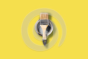 Demonstrating trendy Color of the Year 2021. Illuminating Yellow and Ultimate Gray. Brush and open paint can with on