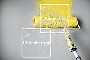 Demonstrating trendy Color of the Year 2021. Illuminating Yellow and Ultimate Gray. Brush and open paint can with on