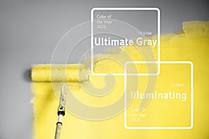 Demonstrating trendy Color of the Year 2021. Illuminating Yellow and Ultimate Gray. Brush and open paint can with on