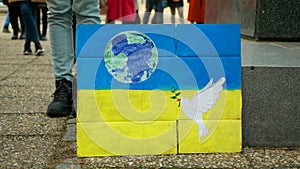 Demonstration people against Russian military attack war Russia on Ukraine flag, banner of hope doves and planet earth