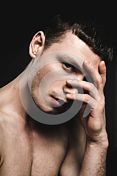Demure man covering nose by hand
