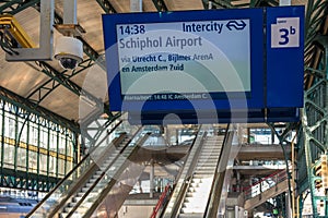 Railway station concourse with information panel and exit sign