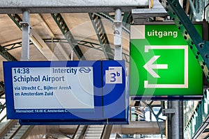 Railway station concourse with information panel and exit sign