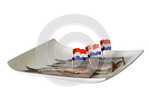 Den Helder, Netherlands. June 2022. Fresh raw herring on a white plate. Isolated. selective focus.