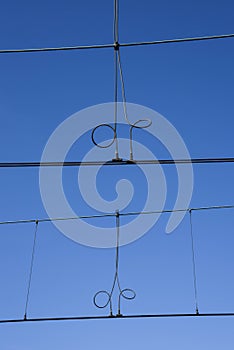 Den Helder, Netherlands, May 2022. The railroad catenary against a blue sky.