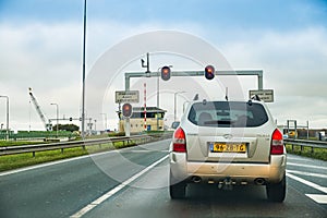 Den Oever, Netherlands - January 09, 2020. Cars waiting on traffic lights before water chanell