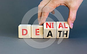 Denial death symbol. Concept words Denial Death on wooden block. Beautiful grey table grey background. Businessman hand. Business