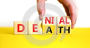 Denial death symbol. Concept words Denial Death on wooden block. Beautiful yellow table white background. Businessman hand.