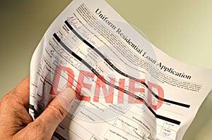 Denied loan application crumpled in hand