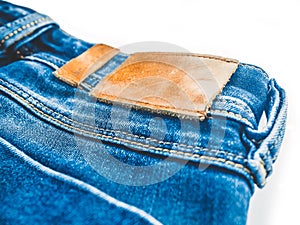 Denim background. Blue jeans with a brown leather label empty space