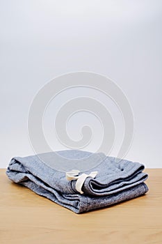 Denim cotton joggers with coulisse folded on a wooden table photo
