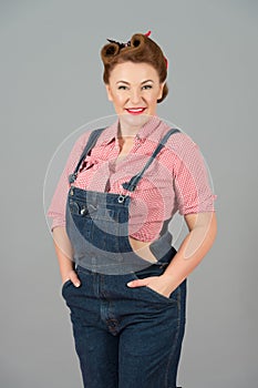 Denim dress and pin-up style repair woman isolated in studio on grey background