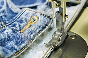 Denim fabric on the sewing machine. Close-up of the sewing process.