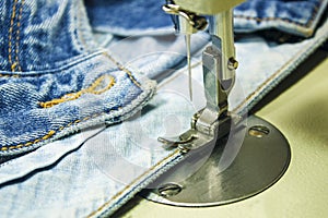 Denim fabric on the sewing machine. Close-up of the sewing process.