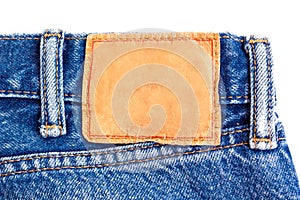 Denim jeans background with blank leather label.