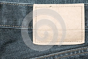 Denim jeans fabric texture background with blank leather label.