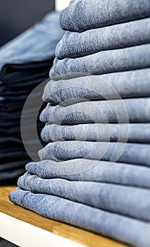 Denim jeans or pants on a shelf in a boutique clothing and apparel store or shop