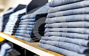 Denim jeans or pants on a shelf in a boutique clothing and apparel store or shop