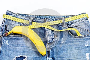 Denim pants with banana imitating male genitals on white background