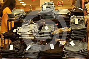 Denim pants folded on display at shopping mall.