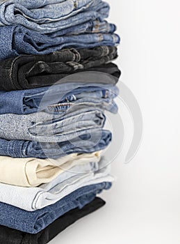 Denim pants stack on white background. Shopping concept.