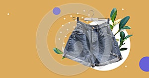 Denim shorts with pockets isolated on abstract colorful background. Fresh plants. Trendy clothes collage. Composition of clothes