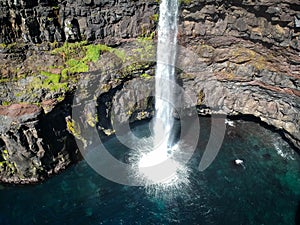 Denmark, Faroe Islands, Vagar Island, Gasadalur, village and waterfall falling into the sea photo