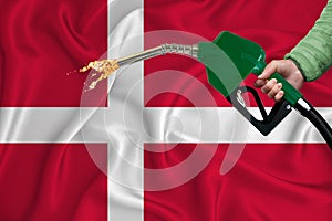 DENMARK flag Close-up shot on waving background texture with Fuel pump nozzle in hand. The concept of design solutions. 3d