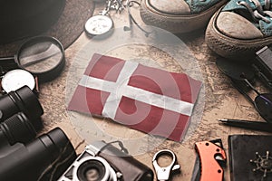 Denmark Flag Between Traveler`s Accessories on Old Vintage Map. Tourist Destination Concept