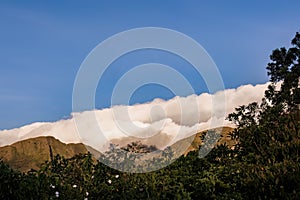 A dense cumulus cloud covers the top of the Iguaque mountain at sunset
