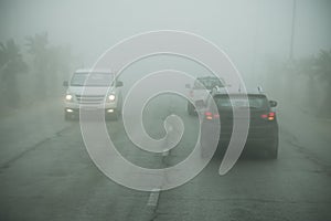 Dense fog and poor visibility on the road. Dangerous driving situations. View on highway traffic. Misty morning. Low visibility.