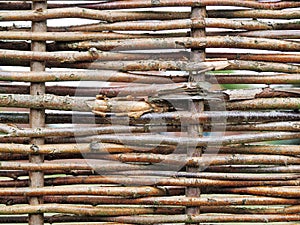 Dense rows of grey weathered willow reeds in an irregular pattern