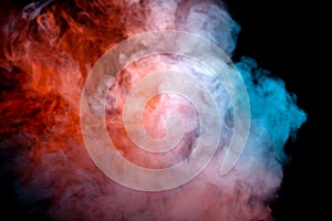 A dense, swirling cloud of colorful smoke against a black background, highlighted in red and blue in waves from the vape