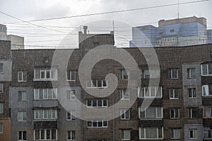 Dense wall of torrential rain in front of high-rise building. Texture of summer downpour. Brick building of apartment building.