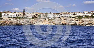 Densely packed apartment blocks with holiday apartments on the steep rocky coast of Mallorca