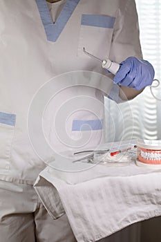 Denstist assistant stays close to the table with stomatological tools. Closeup