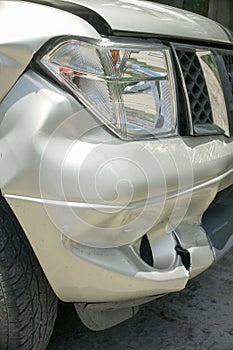 A dent on the left front of a pickup truck (damage from crash)