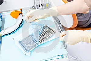 Dental appliances in sterile packaging. Dentist& x27;s hand in gloves