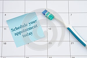 Dental appointment with toothbrush and sticky note on a calendar