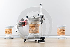 Dental articulator with dental jaw prosthesis model on the table in dental laboratory