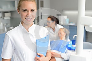 Dental assistant smiling dentist with patient photo