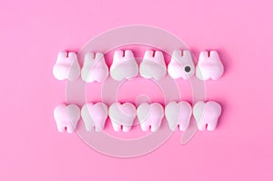 Dental background with models of teeth in two lines. One tooth with caries