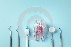 Dental care concept with tooth, toothbrush and dental tools on blue background